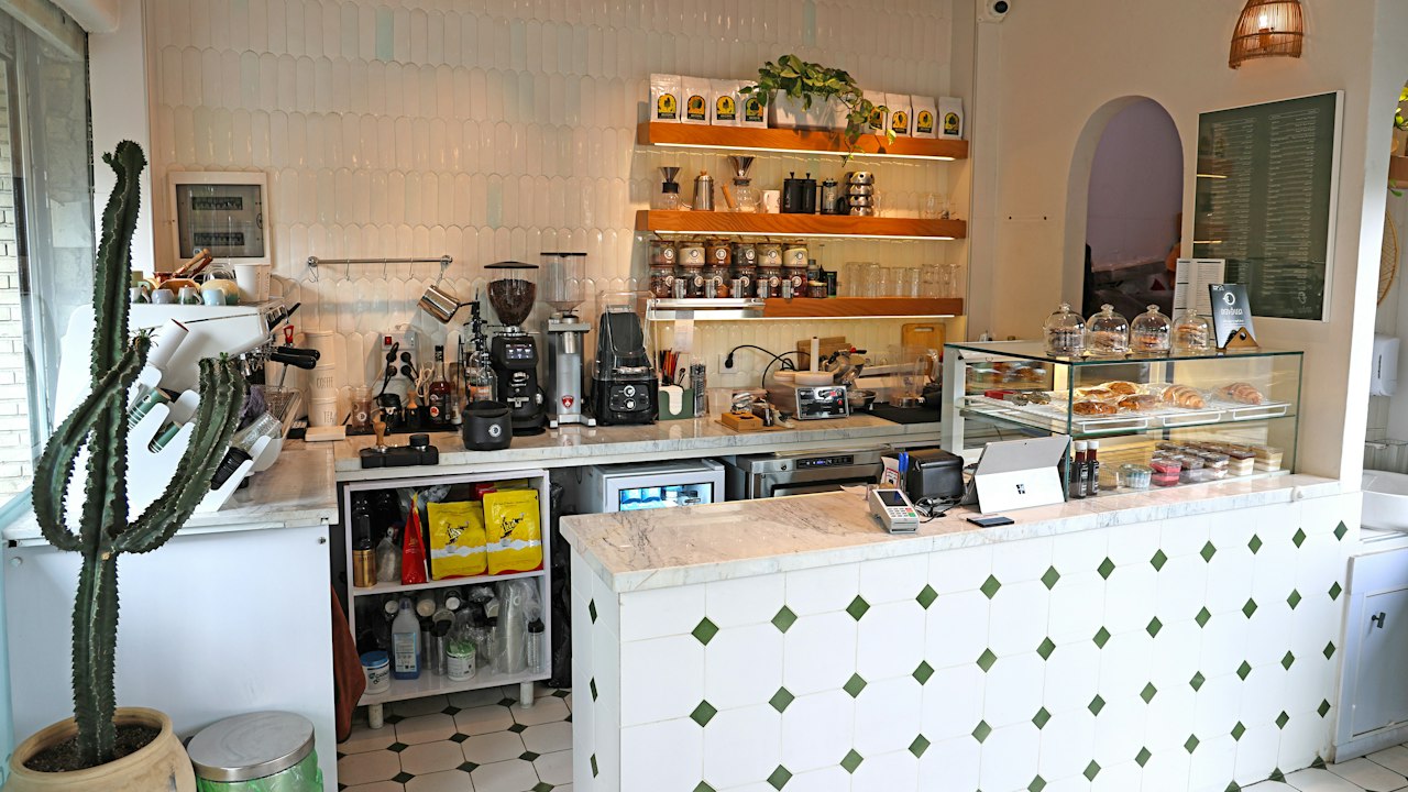 A modern café counter with pastries and coffee equipment